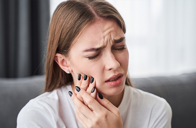 lady with toothache holding her jaw